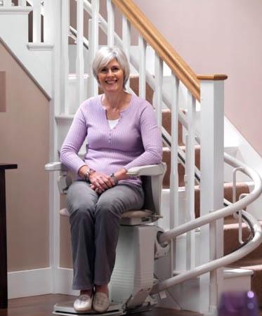 Older Woman on Curved Stannah Stair Lift in Rochester, Ithaca, NY, Buffalo, and Erie