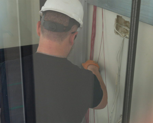 Man Working On Installing A Cibes Air Elevator Workin On Wiring